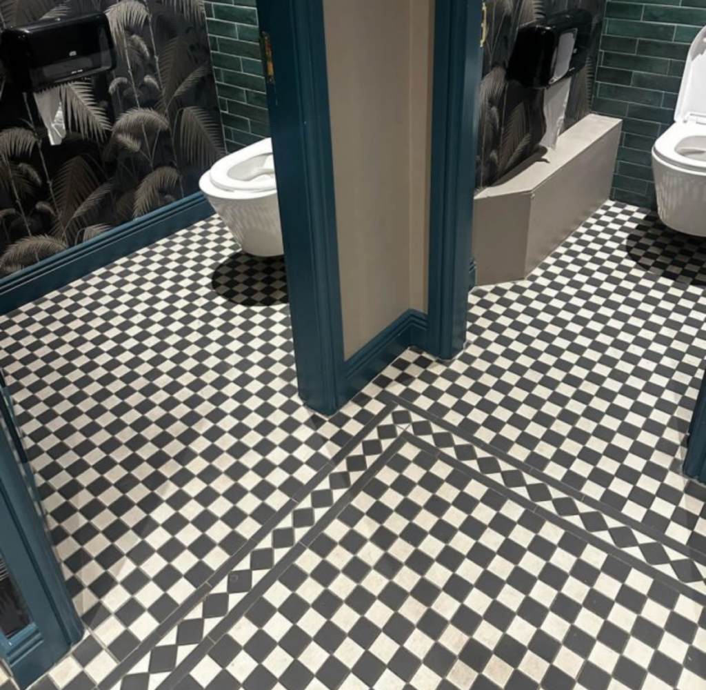 Black and white bathroom floor tiling installation in Stamford